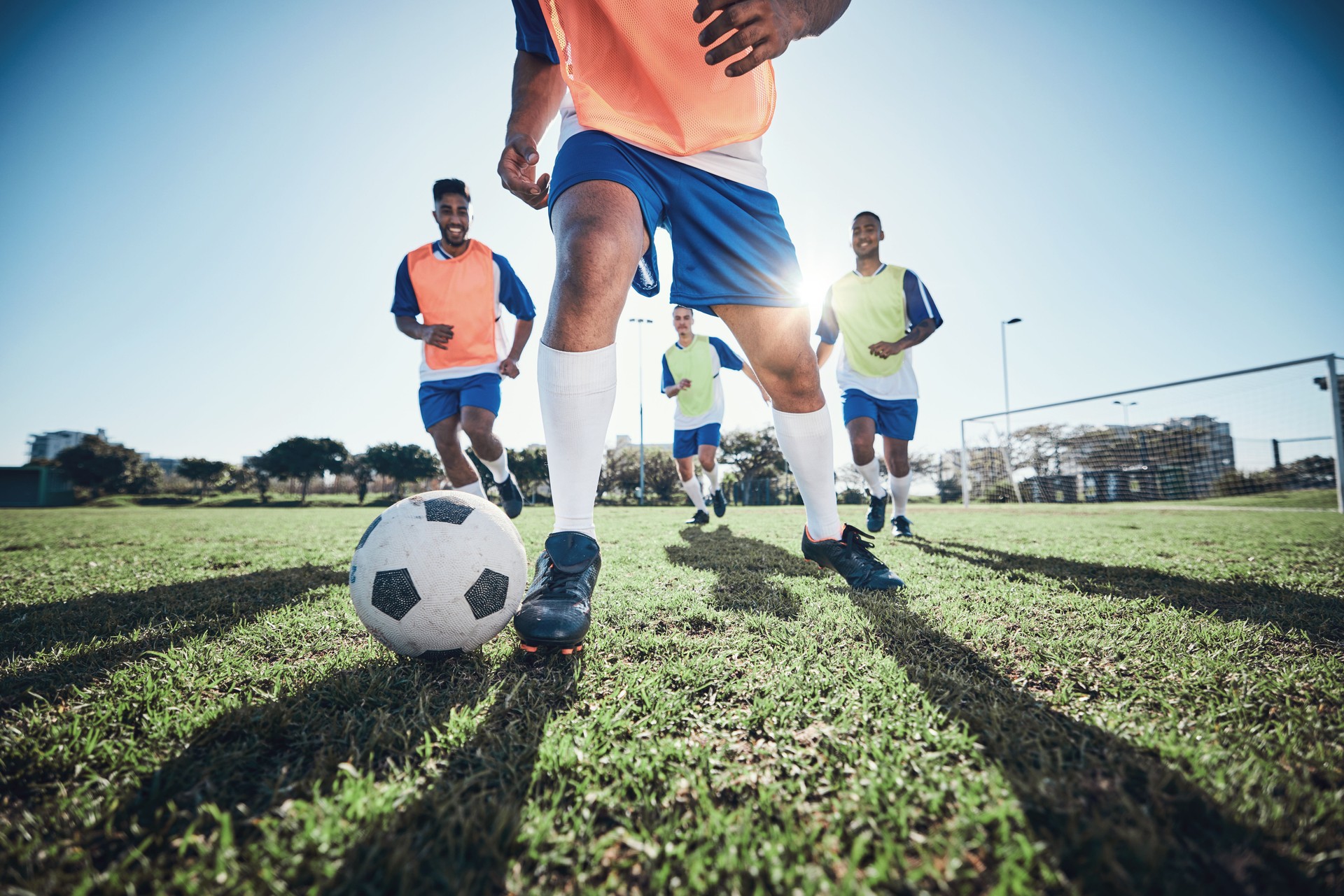 Football, men and exercise with action, field and wellness with workout goal, fitness and competition. Male players, guys and athlete with a challenge, soccer and sports with energy and training