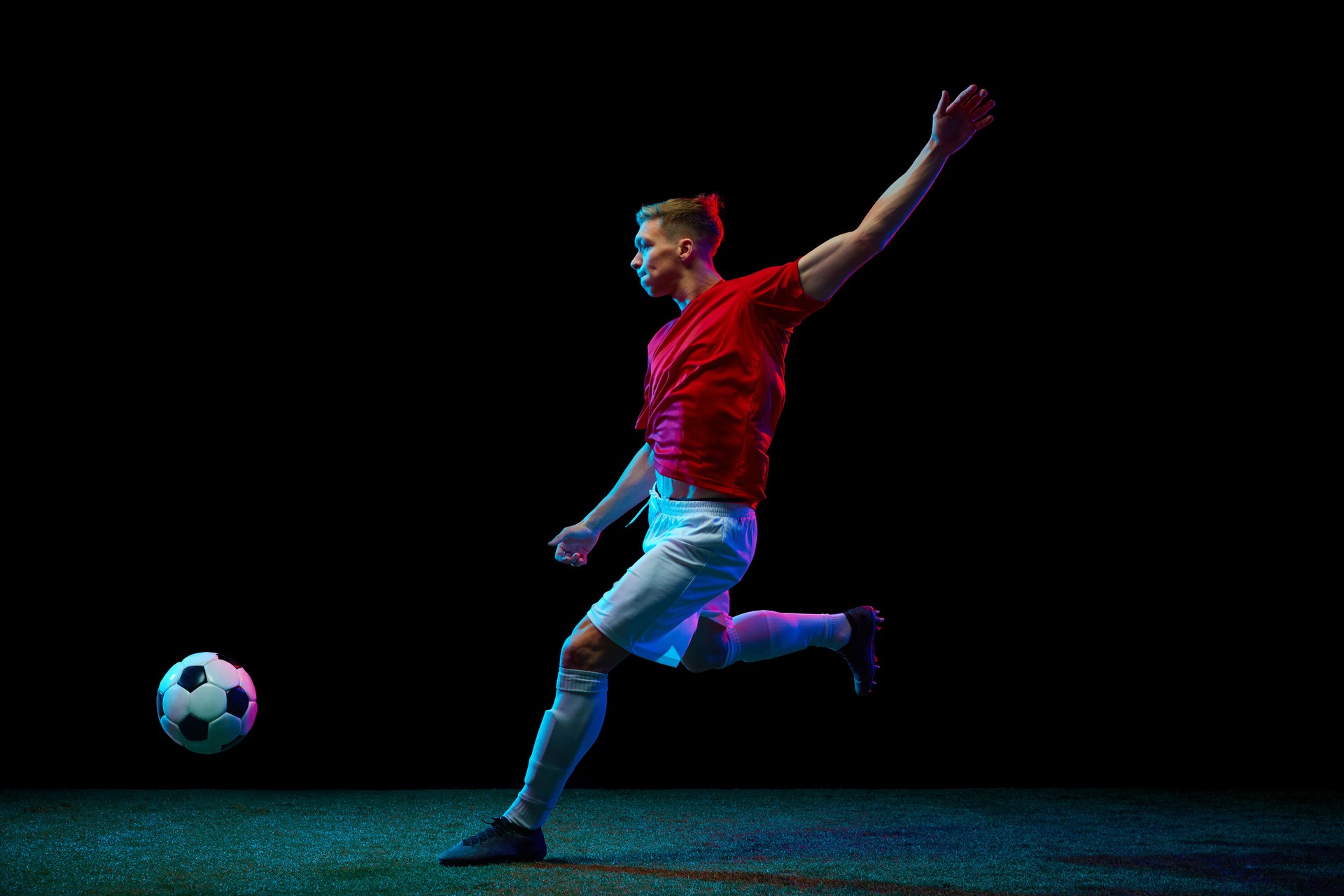 Precision in Motion. skilled football player delivers perfect airborne pass, showcasing unparalleled precision against black background in neon light.